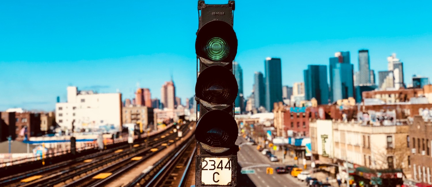 Train tracks running through a city. Photo by Bobby Kasimis on Unsplash